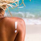 young woman on beach with suntan lotion
