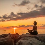 Young woman practicing  yoga on the beach