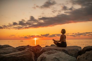 Young woman practicing  yoga on the beach