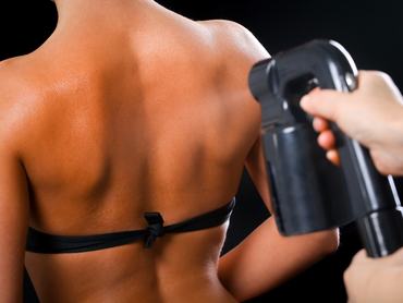 Woman body paint with airbrush in professional beauty salon