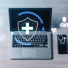 Innovatív digitális egészségügyi technológia pajzs és orvosi ikonokkal laptop képernyőjén és okostelefonján