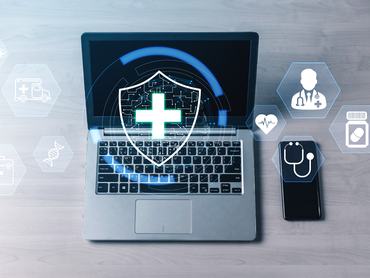 Innovatív digitális egészségügyi technológia pajzs és orvosi ikonokkal laptop képernyőjén és okostelefonján