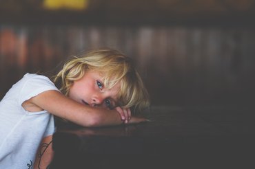 kislány az asztalra borulva